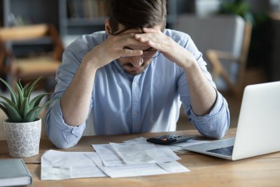 frustrated man looking at bills